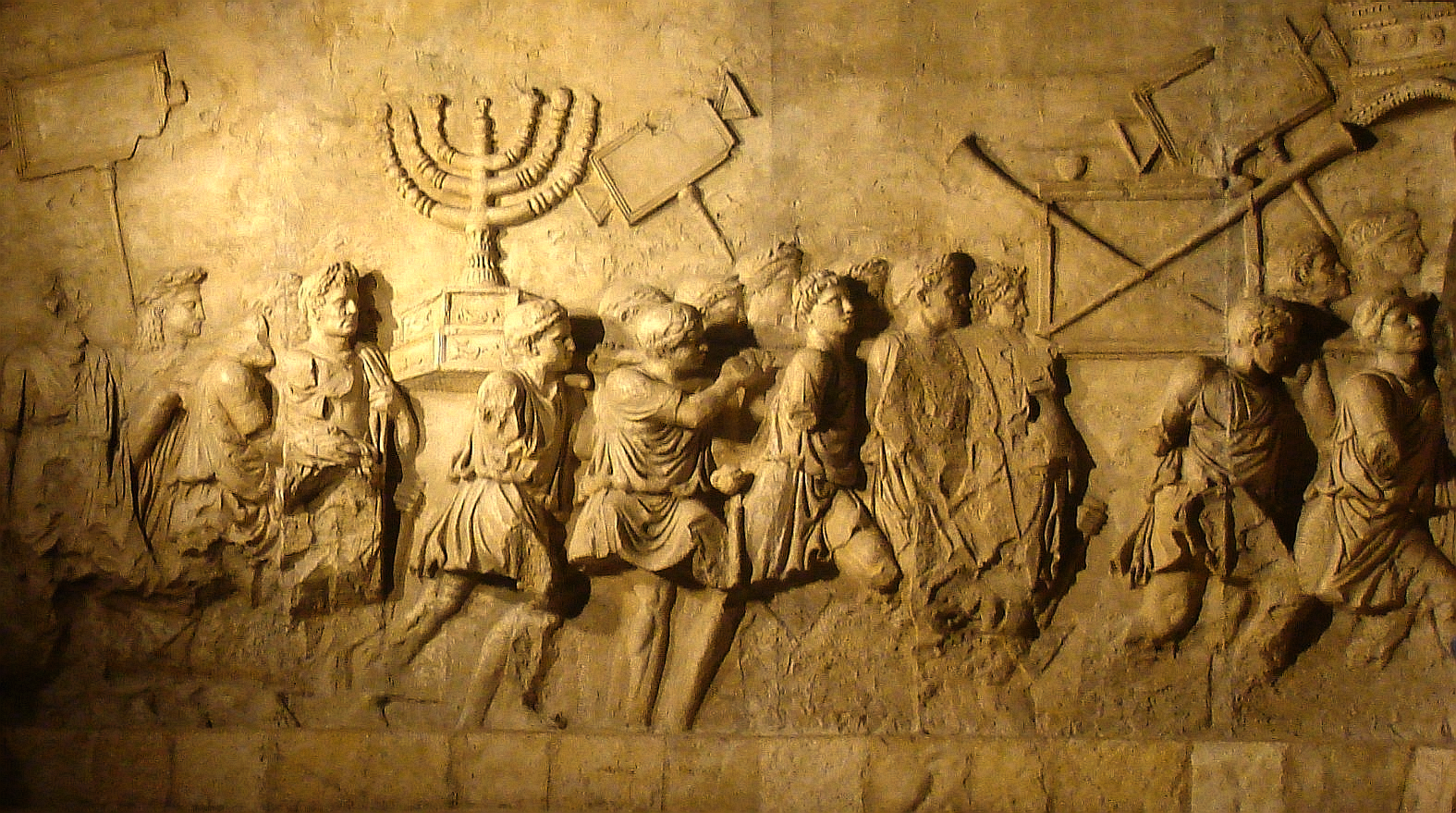 The Arch of Titus relief showing Roman soldiers carrying the golden Menorah and spoils from the Jerusalem Temple in AD 70.